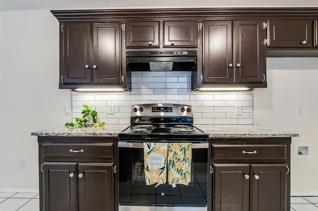 kitchen featuring electric stove, dark brown cabinetry, under cabinet range hood, baseboards, and light tile patterned flooring