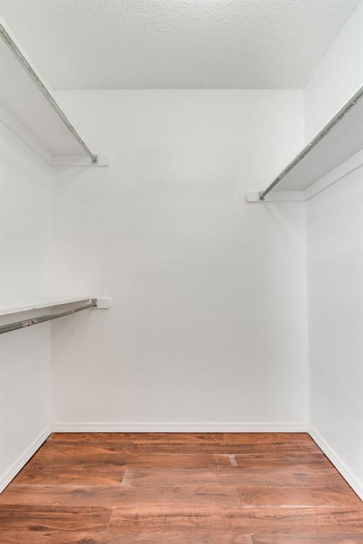 walk in closet with wood finished floors