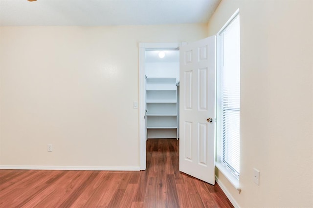 empty room featuring wood finished floors and baseboards