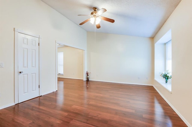 unfurnished room with wood finished floors, ceiling fan, a wealth of natural light, and lofted ceiling