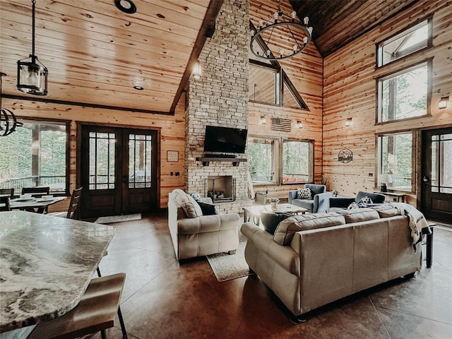 living room with finished concrete flooring, high vaulted ceiling, wood walls, french doors, and wooden ceiling