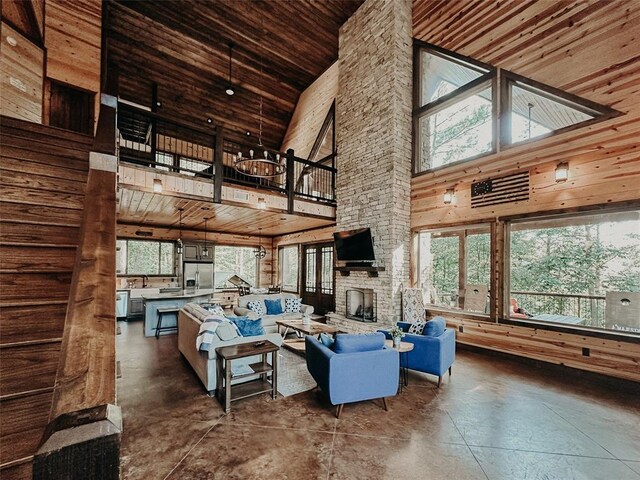 living area with wooden ceiling, a high ceiling, and concrete floors