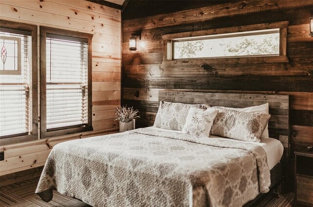 bedroom featuring wooden walls and multiple windows