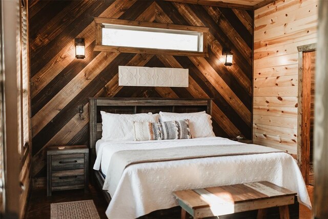 bedroom with wooden walls and lofted ceiling