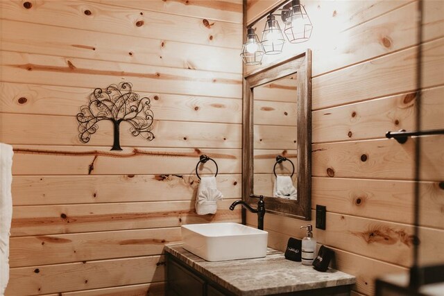 bathroom with vanity and wooden walls