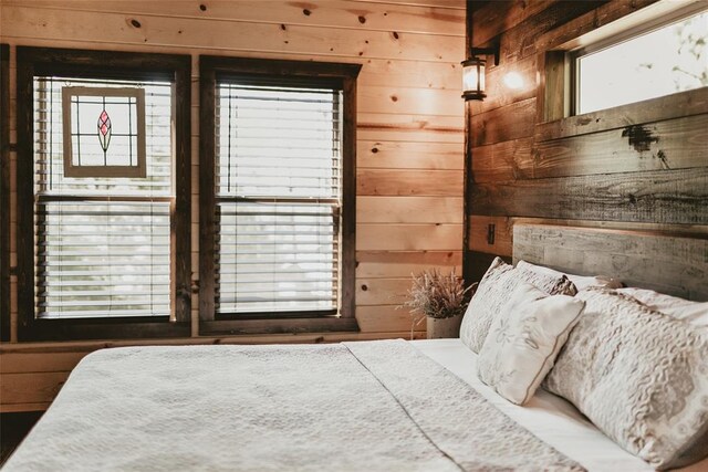 bedroom featuring wooden walls and multiple windows