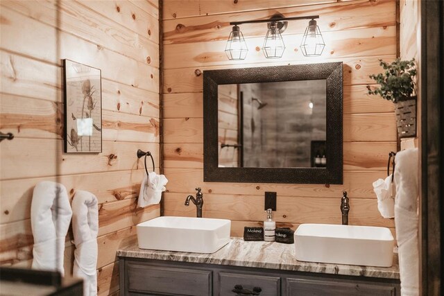 full bathroom featuring double vanity, a sink, and wood walls