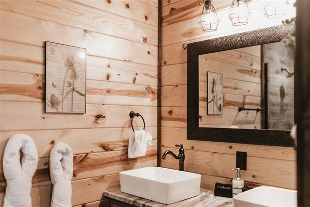 bathroom with vanity and wood walls