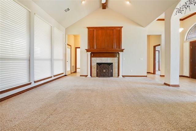 unfurnished living room with a fireplace, baseboards, ceiling fan, beamed ceiling, and light carpet