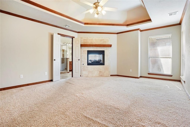 unfurnished living room with a raised ceiling, visible vents, and carpet floors