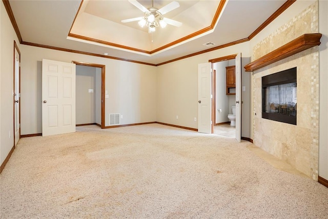 spare room with ornamental molding, ceiling fan, visible vents, a raised ceiling, and light carpet