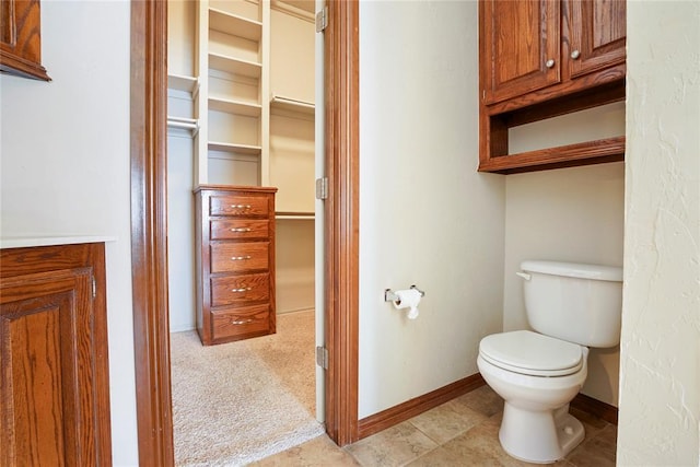 bathroom featuring toilet and baseboards