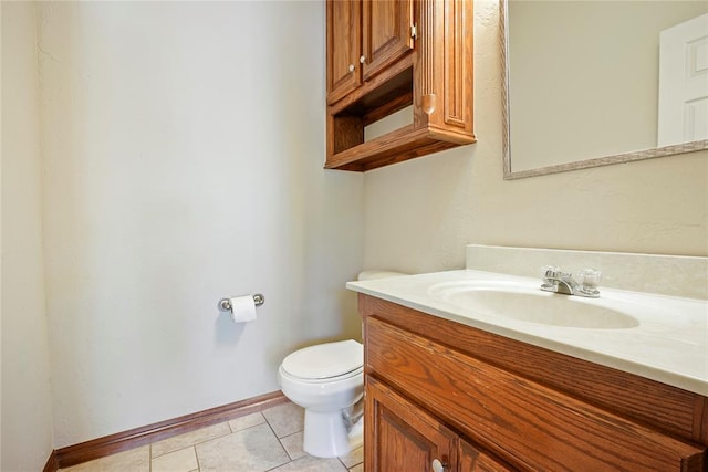 bathroom with vanity, toilet, baseboards, and tile patterned floors