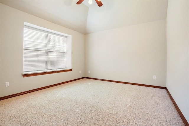 empty room with carpet flooring, baseboards, lofted ceiling, and ceiling fan