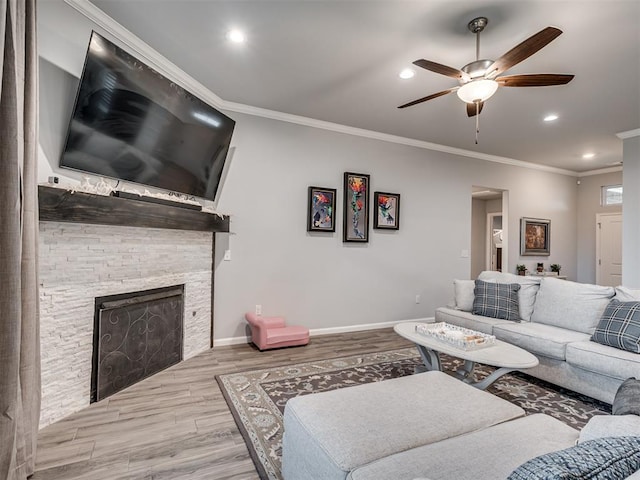 living area featuring recessed lighting, ornamental molding, a fireplace, wood finished floors, and a ceiling fan
