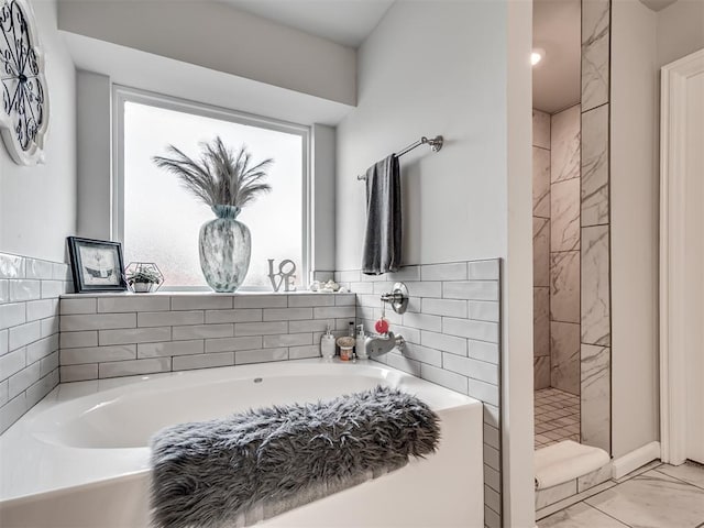 full bathroom featuring a garden tub, a tile shower, and marble finish floor
