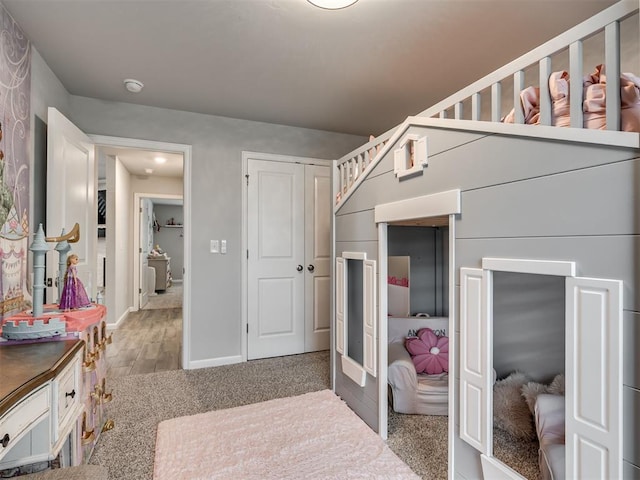 bedroom with baseboards, wood finished floors, and a closet