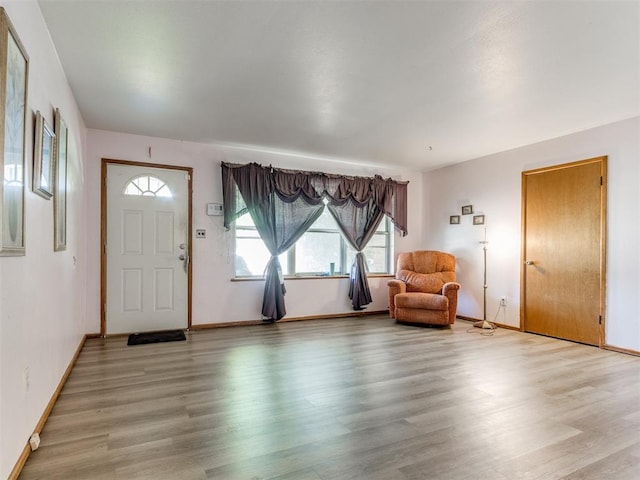 foyer entrance with baseboards and light wood-type flooring