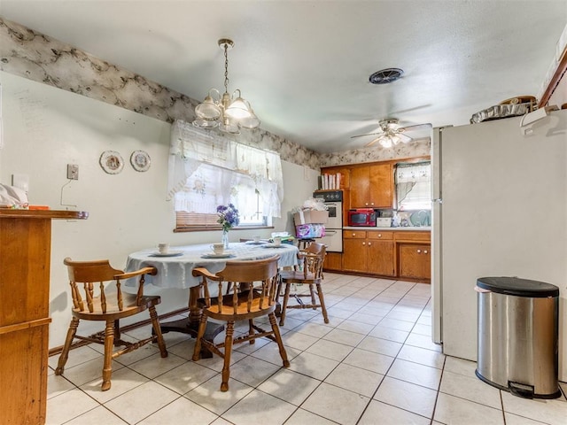 dining area featuring light tile patterned flooring and ceiling fan with notable chandelier