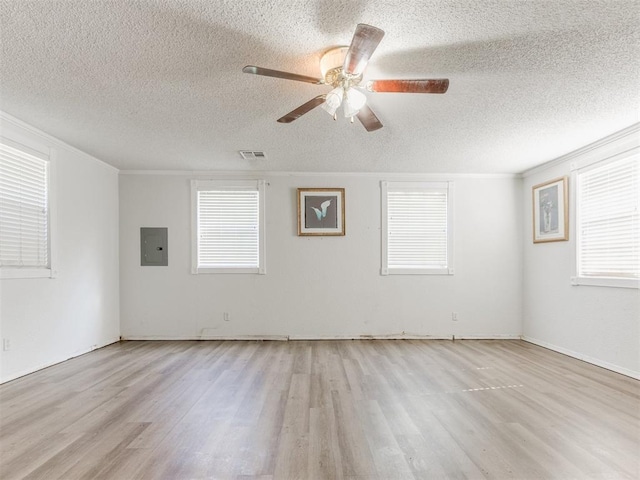 spare room with a textured ceiling, wood finished floors, ceiling fan, and electric panel