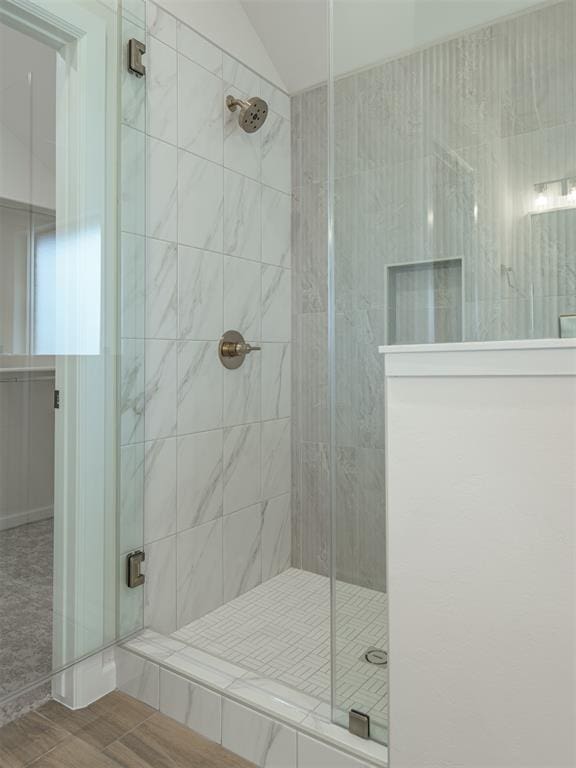 bathroom with lofted ceiling and a shower stall