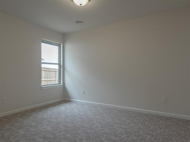 carpeted empty room with visible vents, baseboards, and plenty of natural light