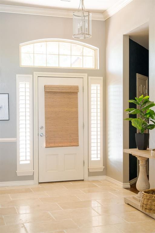 entrance foyer featuring crown molding, baseboards, and a chandelier