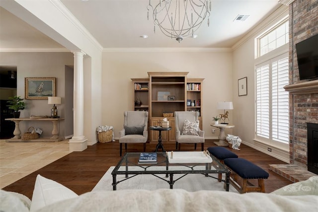 living room with plenty of natural light, ornamental molding, ornate columns, and visible vents