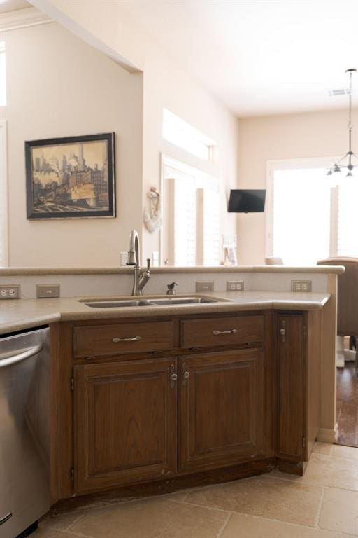 kitchen with stainless steel dishwasher, a healthy amount of sunlight, a sink, and light countertops