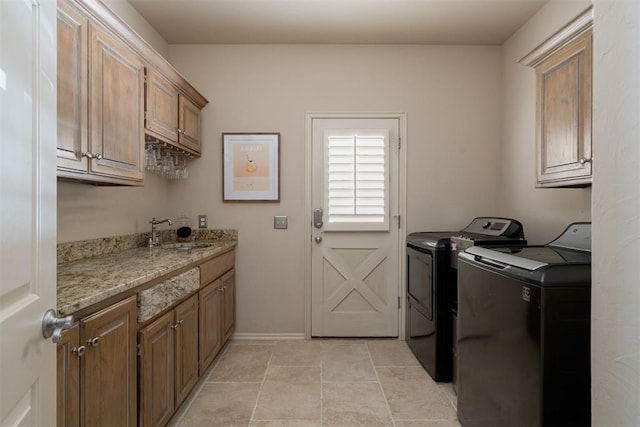 laundry area with baseboards, a sink, cabinet space, and washing machine and clothes dryer