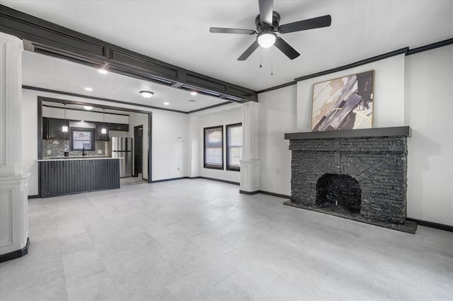 unfurnished living room with ornamental molding, a ceiling fan, baseboards, and a fireplace