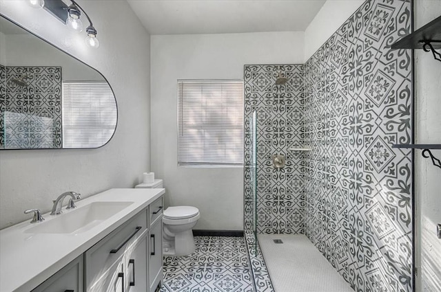 bathroom featuring tile patterned floors, toilet, walk in shower, and vanity