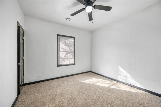 carpeted empty room featuring baseboards, visible vents, and ceiling fan