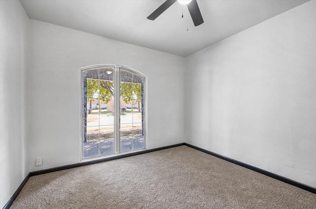 carpeted empty room with baseboards and a ceiling fan