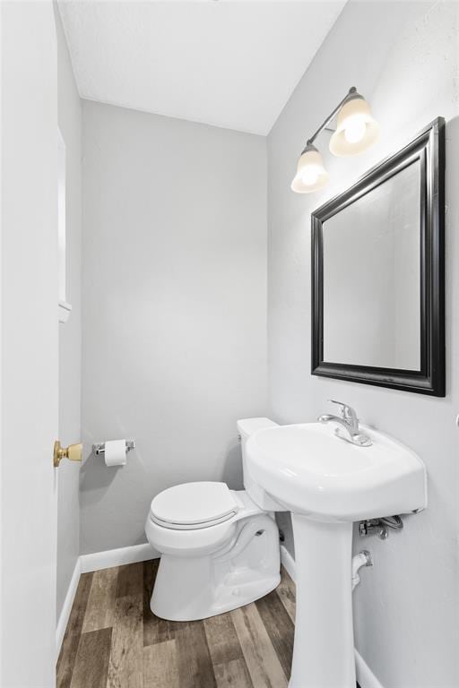 1201 E 18th St, Ada, OK 74820 - half bath with toilet, baseboards, and wood finished floors