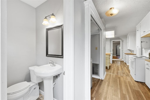 1201 E 18th St, Ada, OK 74820 - bathroom featuring visible vents, baseboards, wood finished floors, and toilet