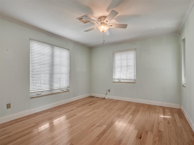 unfurnished room featuring light wood-style floors, a ceiling fan, visible vents, baseboards, and ornamental molding