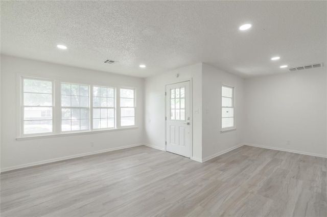 entryway with a textured ceiling, visible vents, and recessed lighting