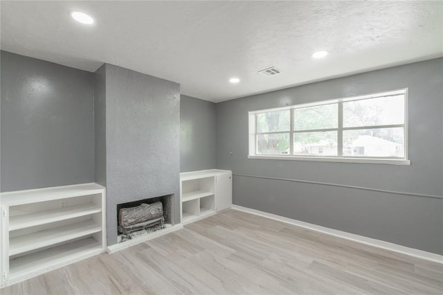 unfurnished living room with wood finished floors, visible vents, recessed lighting, and baseboards