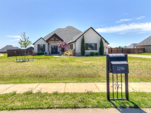 single story home featuring a front lawn, stucco siding, and fence
