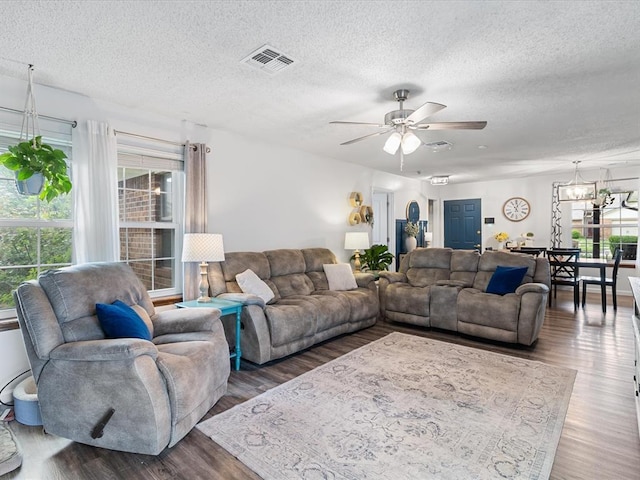 living room featuring a healthy amount of sunlight, a ceiling fan, a textured ceiling, and wood finished floors