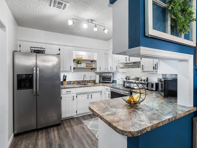 kitchen with dark wood-style flooring, visible vents, appliances with stainless steel finishes, a sink, and a peninsula
