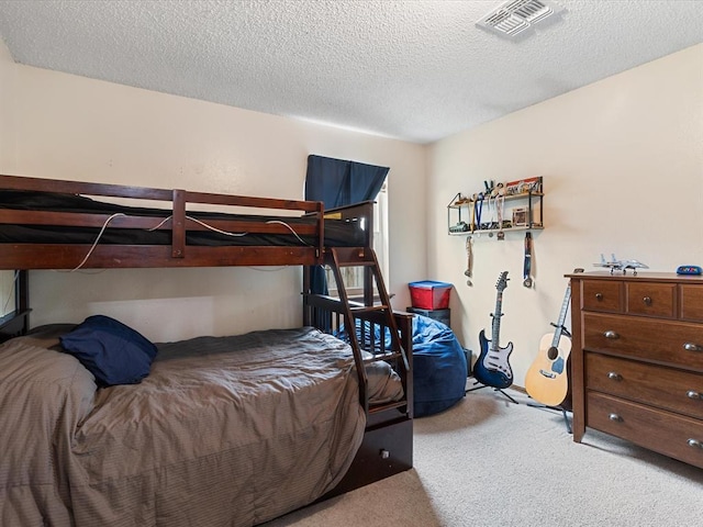 carpeted bedroom with a textured ceiling and visible vents