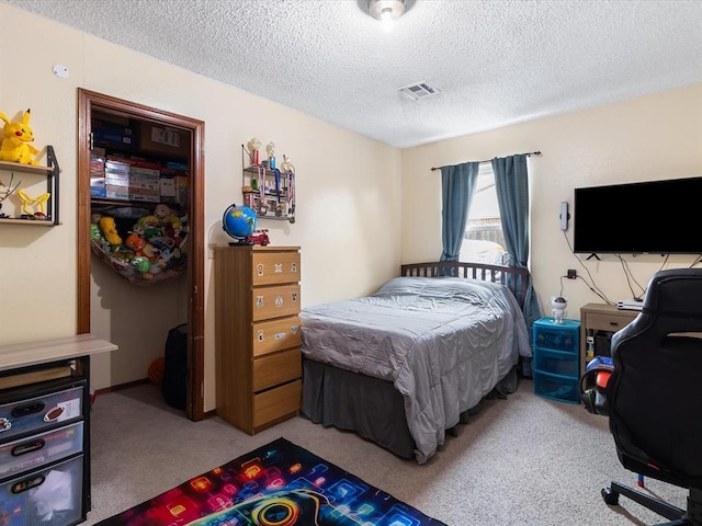 bedroom featuring visible vents, a textured ceiling, and carpet