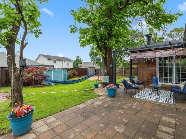 view of patio / terrace with a fenced backyard, a pergola, a shed, and an outbuilding
