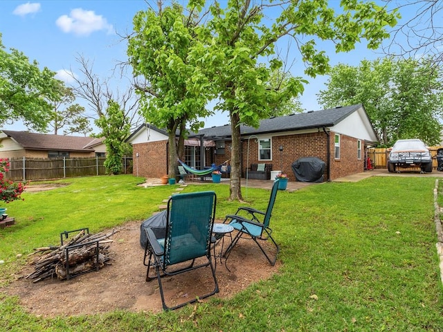 view of yard with fence, a patio, and a fire pit