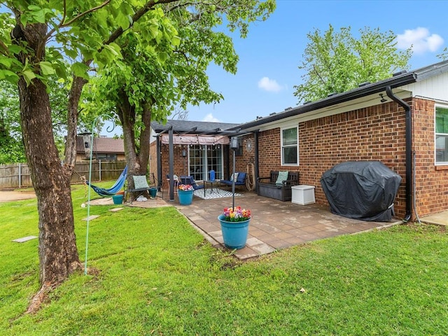 back of property featuring fence, a patio, a lawn, and brick siding