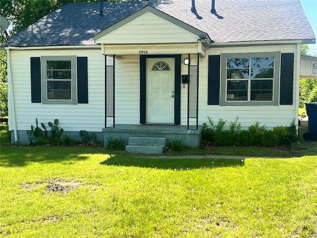 bungalow-style home featuring a shingled roof and a front lawn