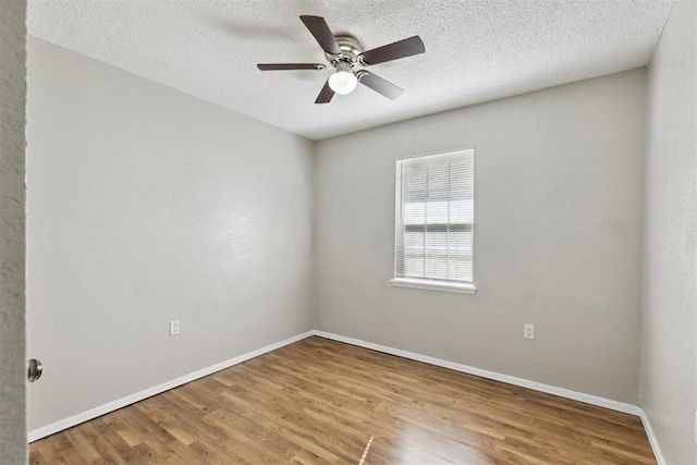 586 Seikel Dr, Choctaw, OK 73020 - unfurnished room featuring wood finished floors, baseboards, ceiling fan, and a textured ceiling