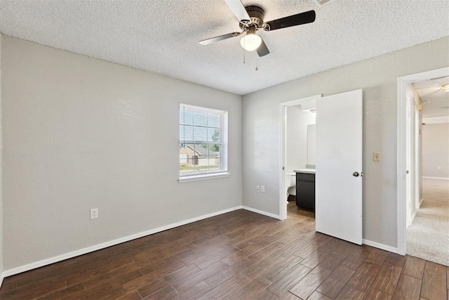 586 Seikel Dr, Choctaw, OK 73020 - unfurnished bedroom featuring dark wood-style floors, a textured ceiling, baseboards, a ceiling fan, and ensuite bathroom